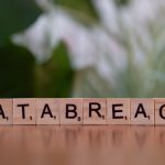 Scrabble tiles spelling 'data breach' on a blurred background, illustrating the warning signs of a personal data breach