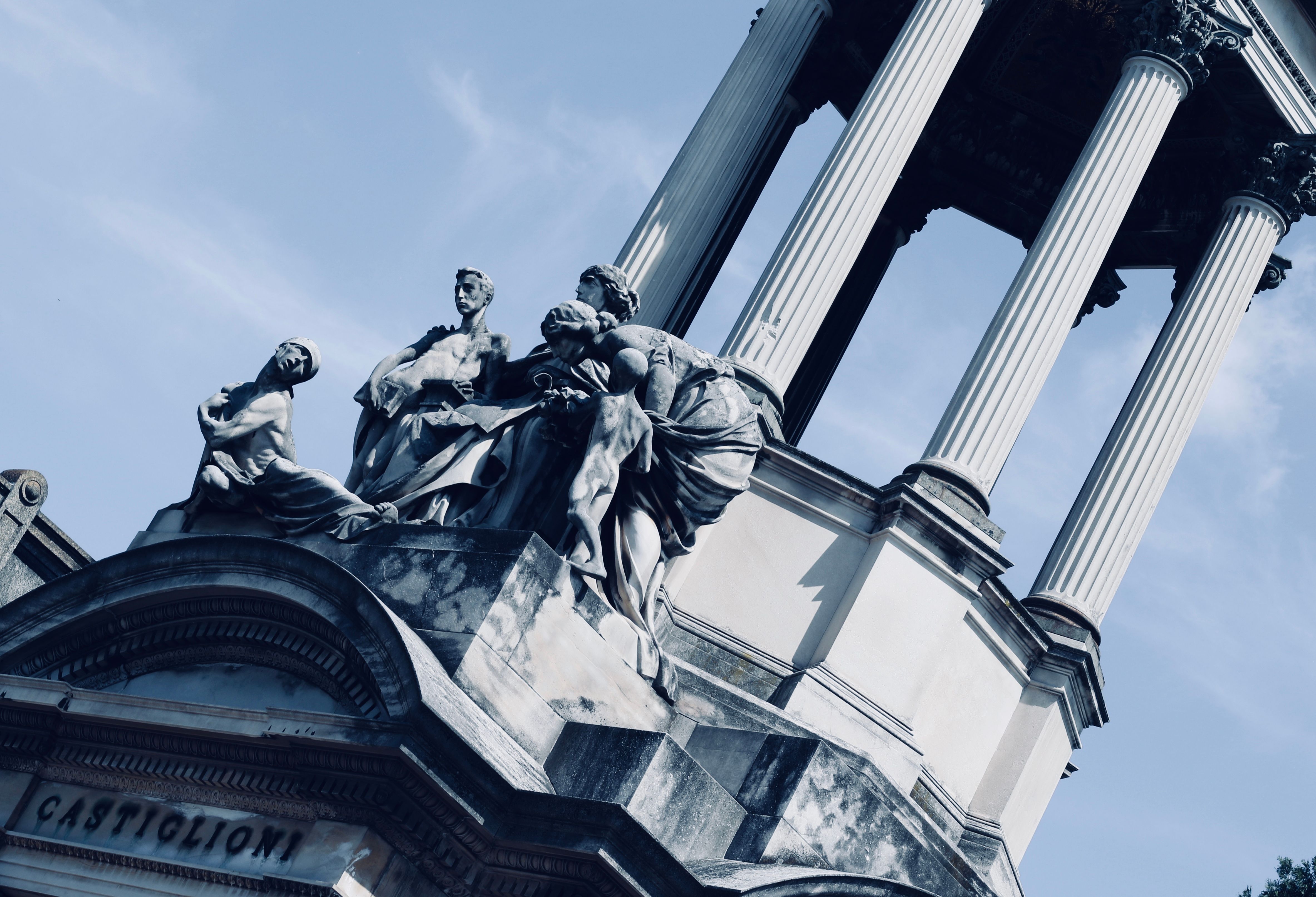 Classical stone monument with columns and sculptures, symbolizing a toppled hero statue and fallen reputation