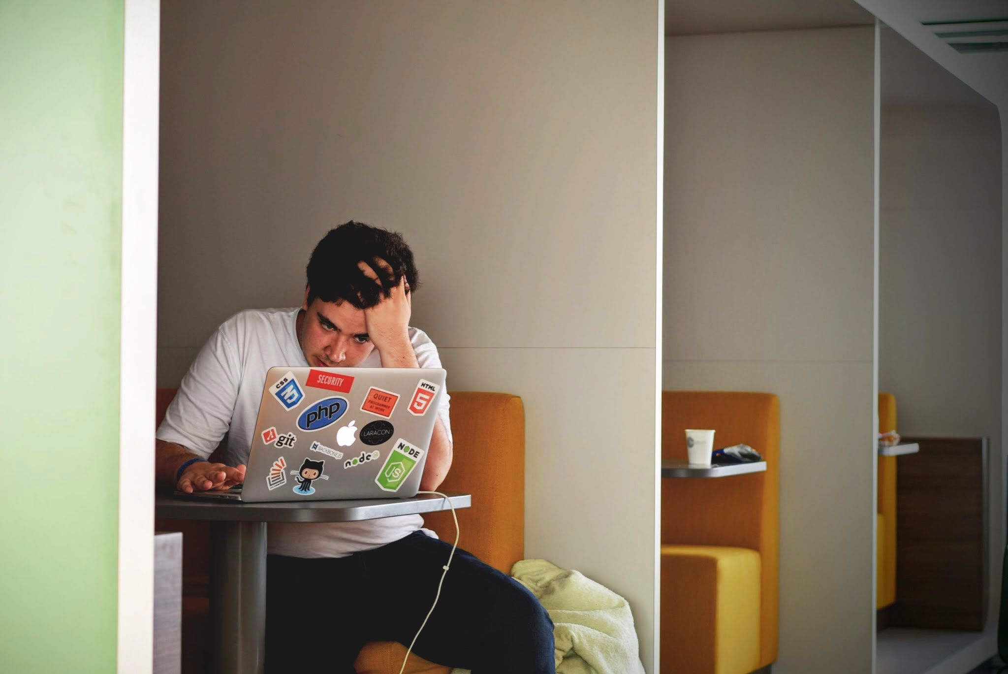 Stressed web developer holding his head while working on a slow WordPress website