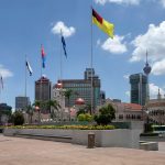 Merdeka Square in Kuala Lumpur with the city skyline under a clear blue sky, the historic heart of Malaysian politics
