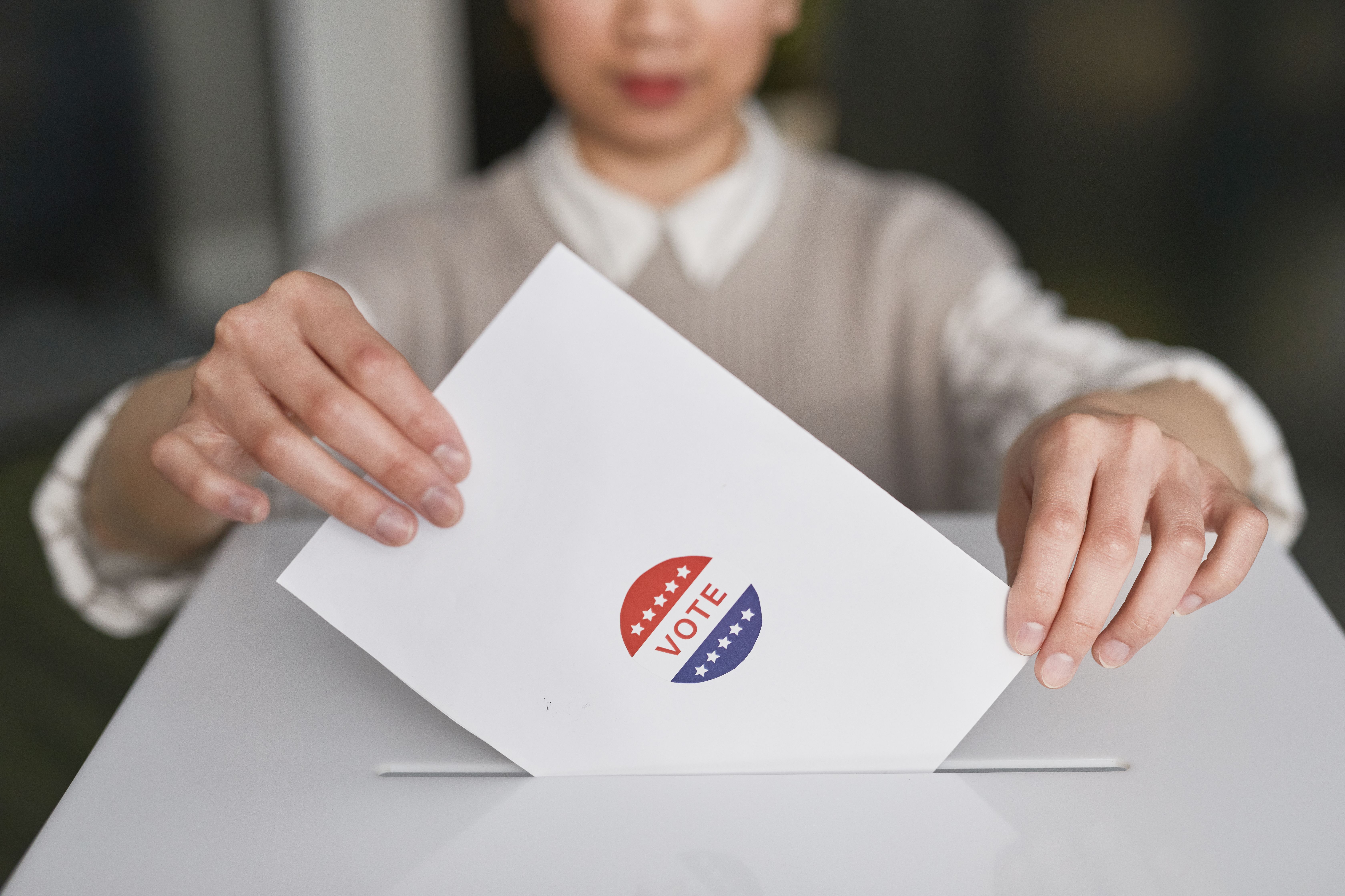 A voter casting a ballot into a ballot box, symbolising Malaysia's general election and coalition building