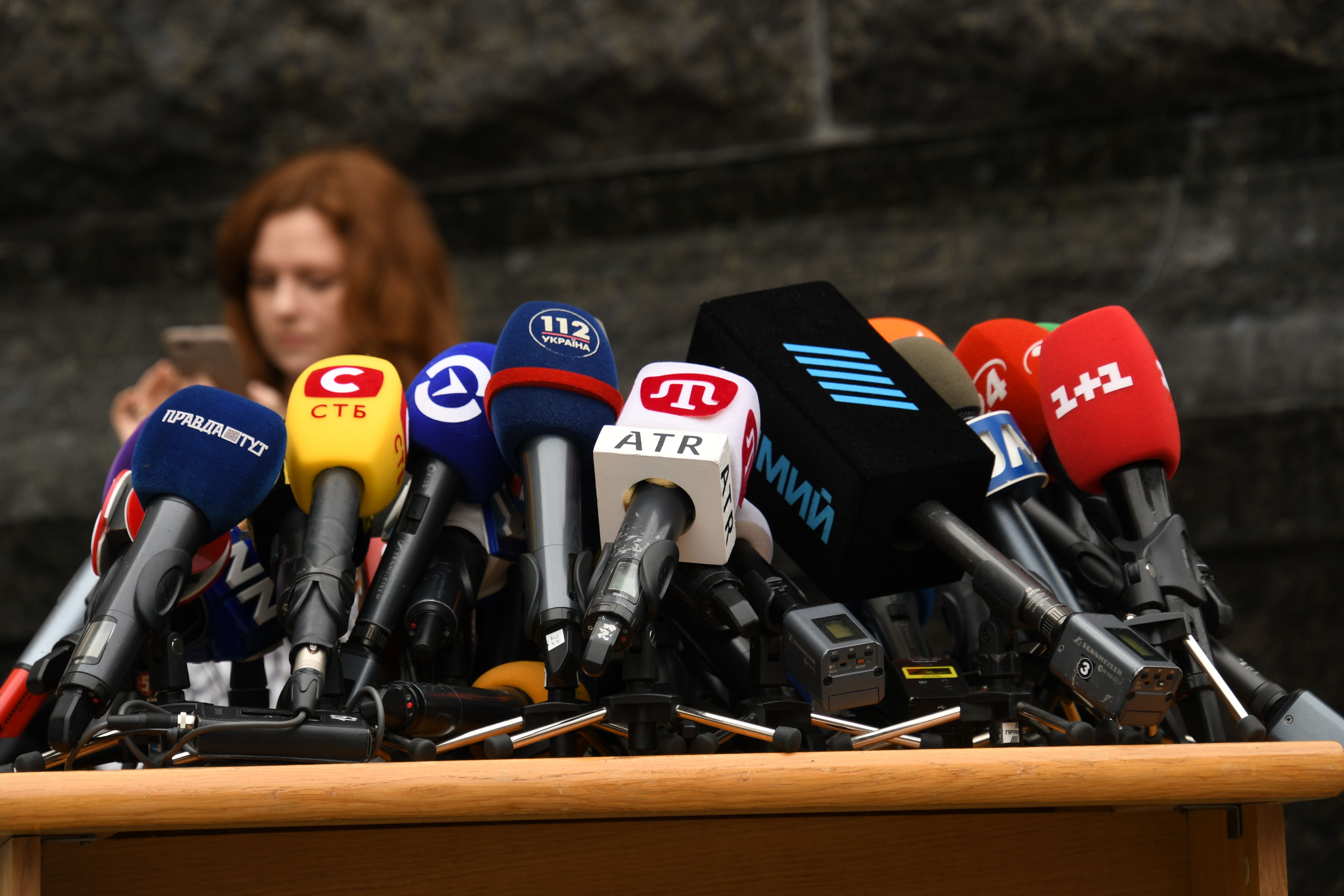 Row of microphones set up for a press conference, representing media scrutiny of public figures
