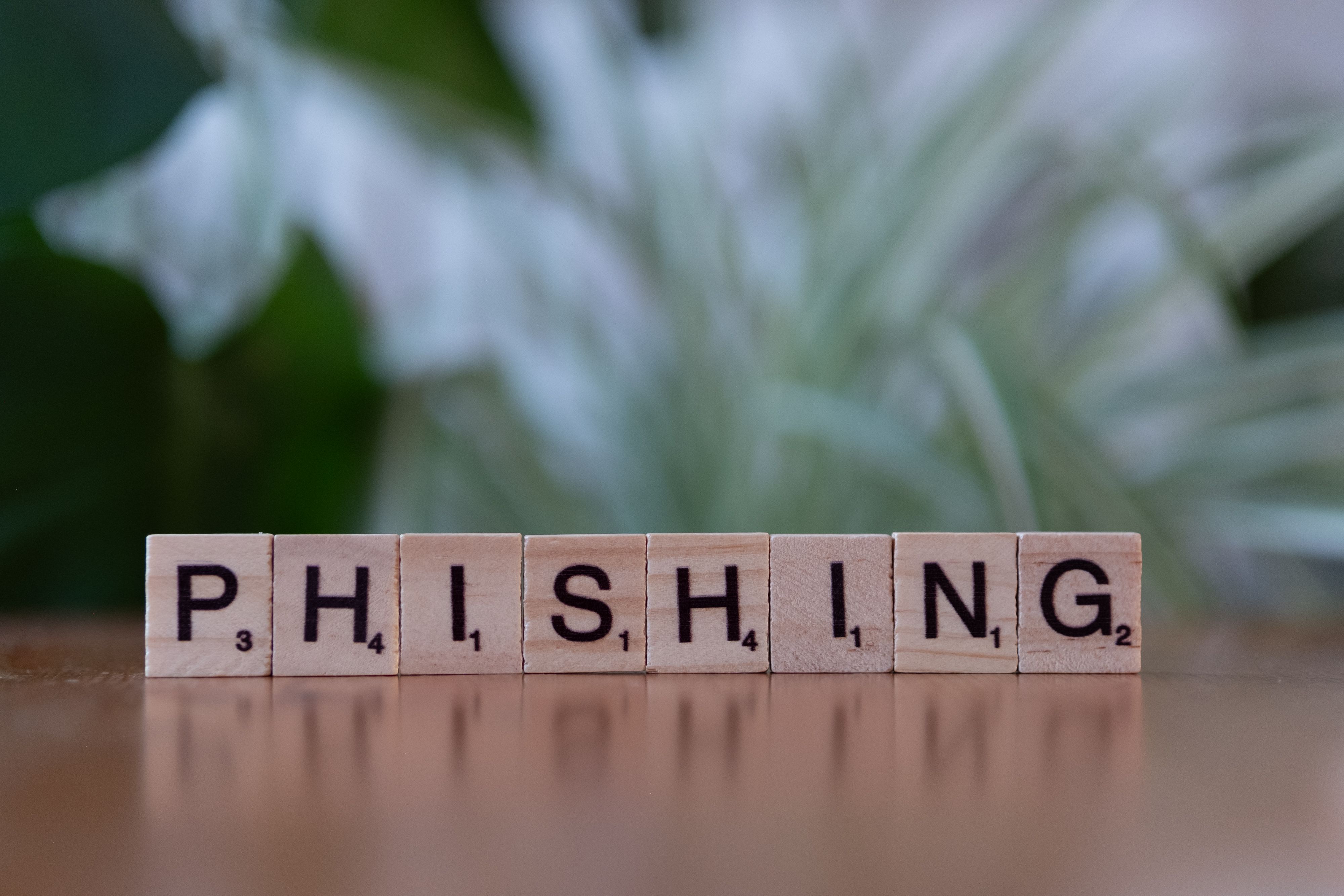 Wooden tiles spelling 'phishing' highlighting the phishing scams used to steal personal data