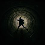 Silhouette of a person falling through a dark tunnel, symbolizing a public figure's dramatic fall from grace