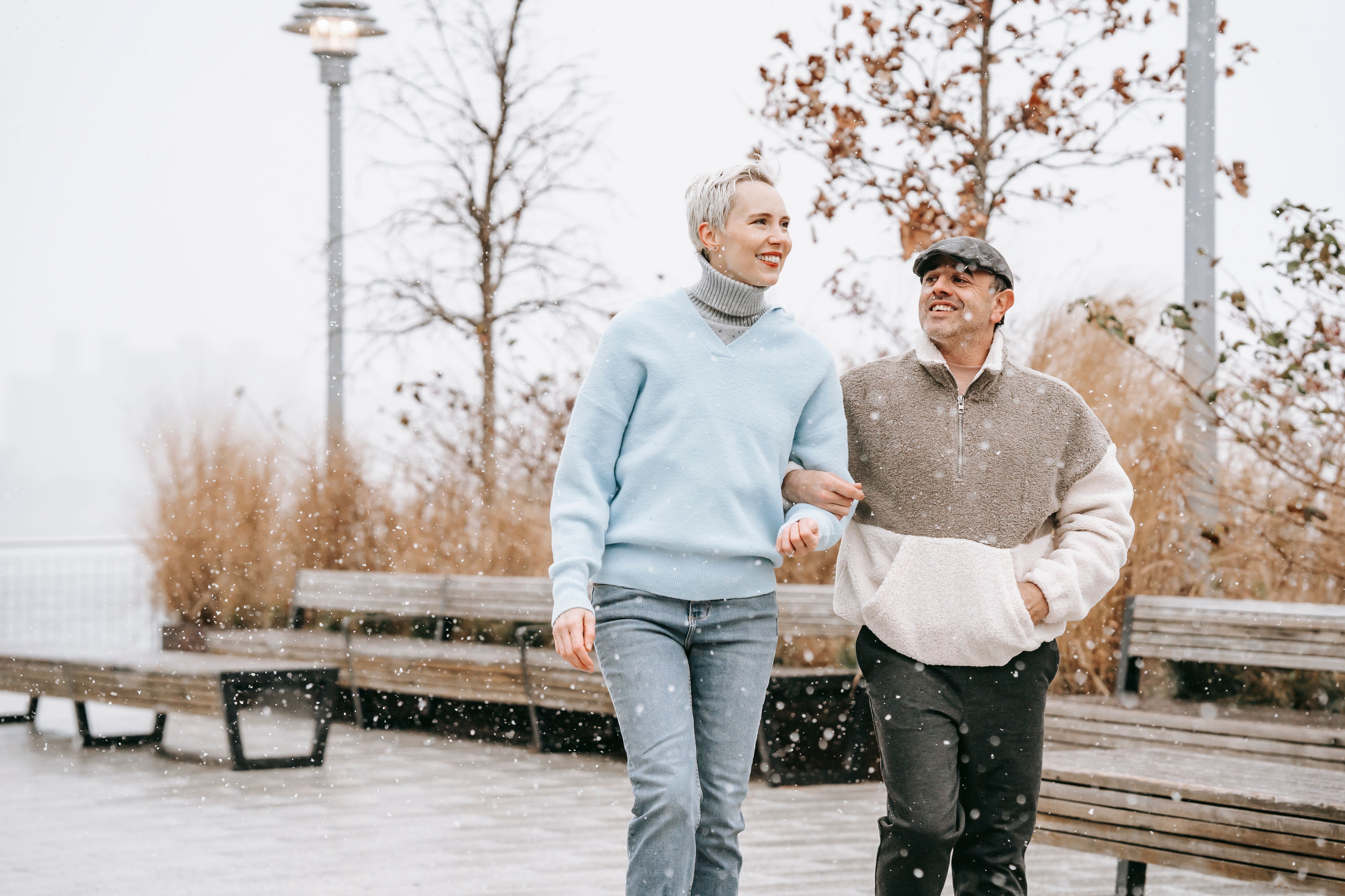 A couple walking together and talking on a city walkway, illustrating connection and communication in relationships.