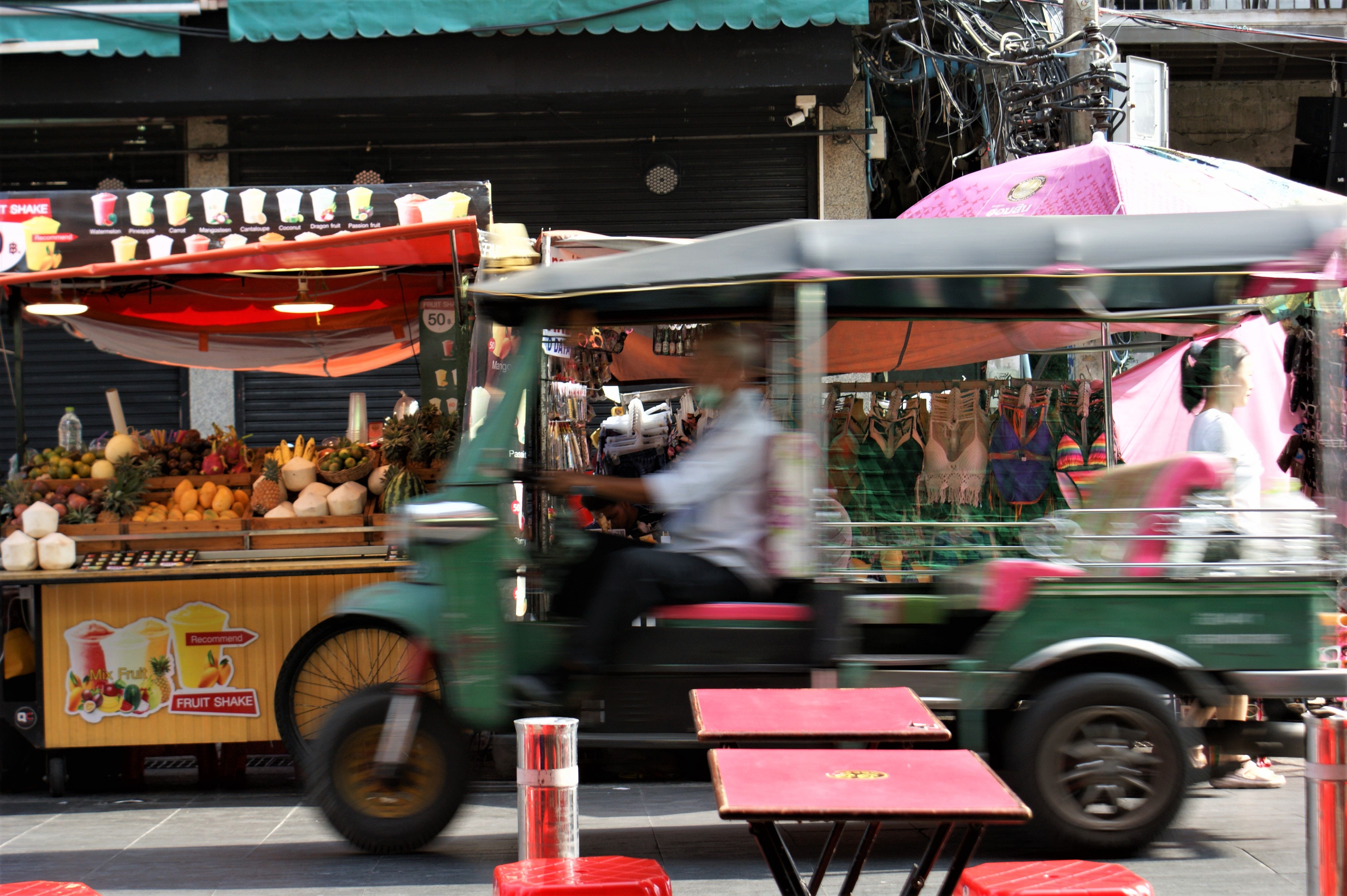 Vibrant Bangkok street scene with a tuk tuk and colorful market stalls