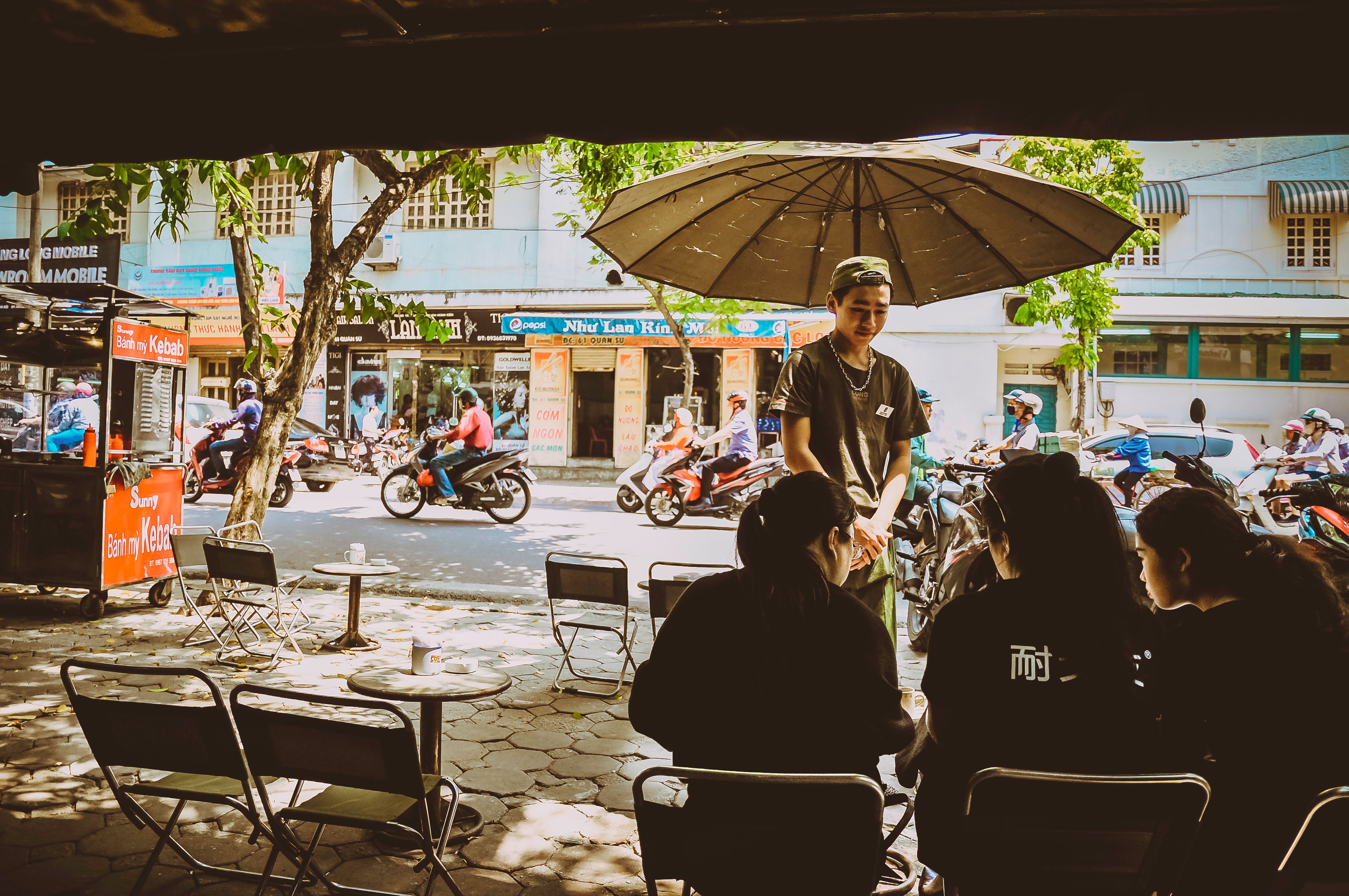 Bustling street cafe in Hanoi, Vietnam with people dining outdoors